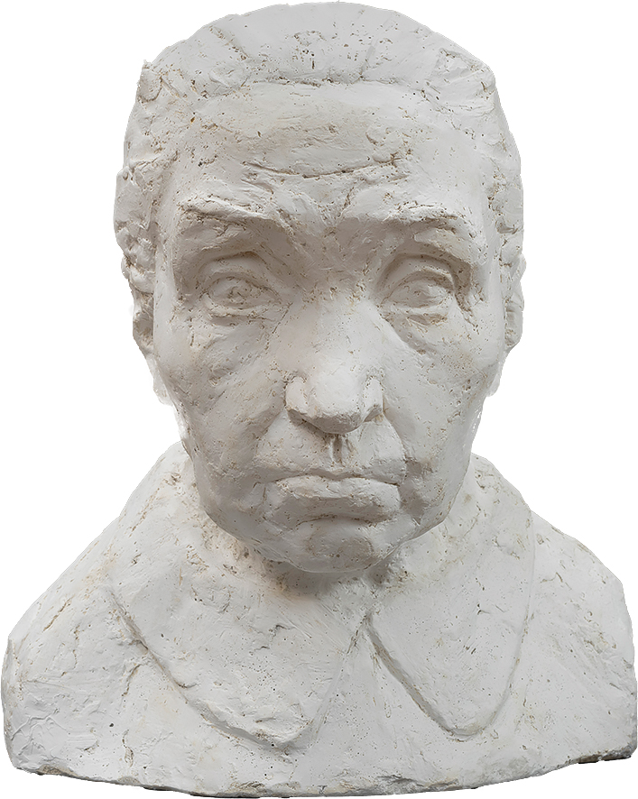 Piotr Waligóra
1909 Sechna Ujanowice – 1968
Staruszka

powstała około 1955 roku

Gips 
38 x 33,5 x 32 cm
Muzeum Zamoyskich w Kozłówce
MPK/SW/214

Rzeźba przedstawia starszą kobietę, ukazaną frontalnie – od klatki piersiowej w górę. Wykonana z jasnego, niemal kredowobiałego gipsu, emanuje surowością i szczerością materiału. Jej powierzchnia nie została wygładzona – przeciwnie, pełna jest zagłębień, rys i śladów co podkreśla ekspresyjny charakter pracy.

Twarz kobiety przyciąga uwagę swoją intensywnością – poważna, poorana zmarszczkami, nosi wyraźne piętno wieku i doświadczenia. Wysokie, pomarszczone czoło i uniesione brwi sugerują zatroskanie lub głęboką refleksję. Nos jest mocno zaznaczony, prosty, a zaciśnięte, opadające usta nadają twarzy surowy, niemal bolesny wyraz.

Oczy skierowane są przed siebie – jakby w spojrzeniu utkwiła pamięć minionych lat lub niepokój o to, co nadejdzie. Gładko zaczesane do tyłu włosy ściśle przylegają do czaszki, wzmacniając wrażenie dyscypliny i oszczędności formy.

Zarys ubrania jest szkicowy – jedynie zaznaczony kołnierzyk przywodzi na myśl skromny fartuch lub prostą suknię, wzmacniając wrażenie codzienności i pokory.

Choć utrzymana w realistycznej konwencji, rzeźba mówi przede wszystkim emocjami. To portret kobiety, którą życie naznaczyło ciężarem, ale nie pozbawiło godności. Jest w niej cicha duma, zmęczenie, siła – i opowieść, której nie trzeba wypowiadać.