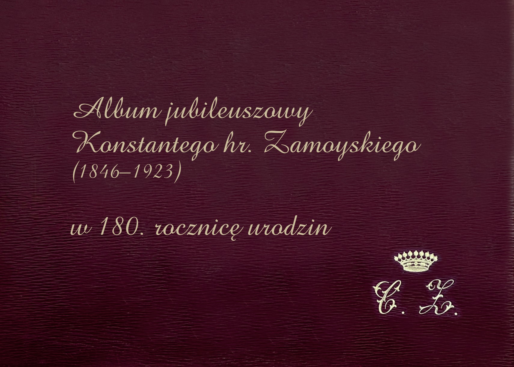 Na fotografii widoczna jest okładka eleganckiego, jubileuszowego albumu. Tło ma kolor ciemnego, głębokiego bordo z delikatną fakturą przypominającą skórę. W centralnej części, lekko przesunięty ku górze, znajduje się złocisty napis wykonany ozdobną, kaligraficzną czcionką. Tekst brzmi: „Album jubileuszowy Konstantego hr. Zamoyskiego (1846–1923) w 180. rocznicę urodzin”. Litery są smukłe, pochyłe i dekoracyjne, nadają całości uroczysty, historyczny charakter.
W prawym dolnym rogu umieszczono niewielką złotą koronę. Pod nią widnieją inicjały „C. Z.” zapisane tą samą elegancką, kaligraficzną czcionką. Całość sprawia wrażenie ekskluzywnej, pamiątkowej publikacji o podniosłym i reprezentacyjnym charakterze.