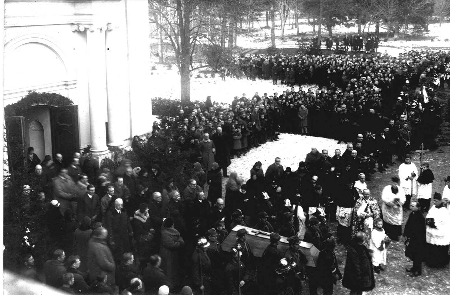 Fotografia archiwalna, czarno-biała, wykonana 12 stycznia 1930 roku, przedstawia moment wyjścia z kaplicy pałacowej w Kozłówce procesji pogrzebowej z trumną z ciałem zmarłej Marii Zamoyskiej.